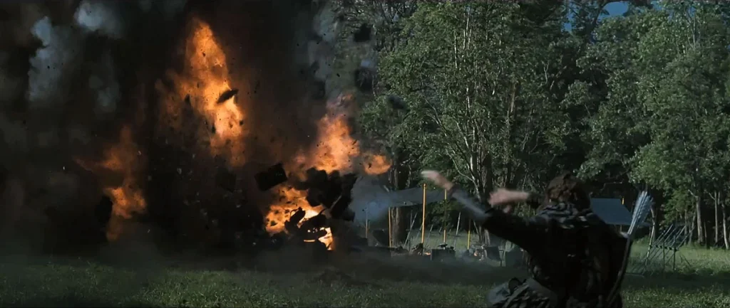 Explosion with a young woman falling backwards; trees in the background