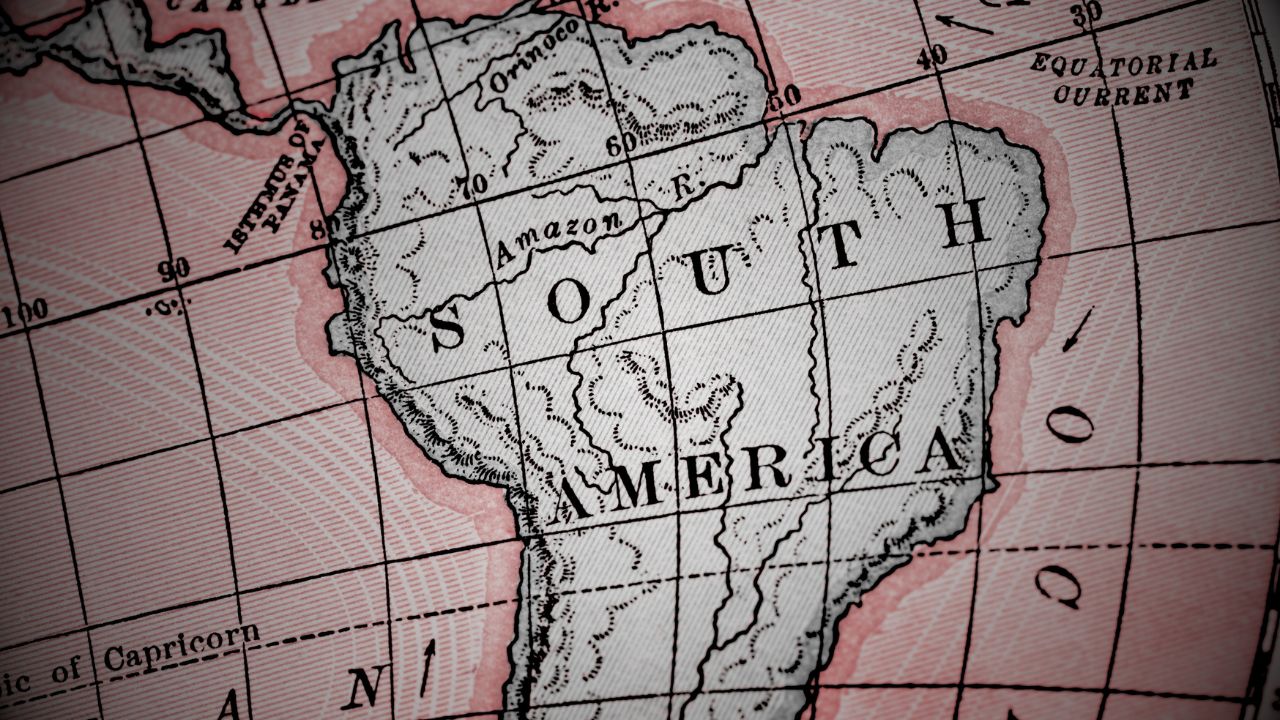 Zoomed in on South America on a vintage map. The sea is in a light shade of red, while the continent is black and white. A vignette filter casts over the map.