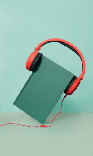 green book with red headphones over it