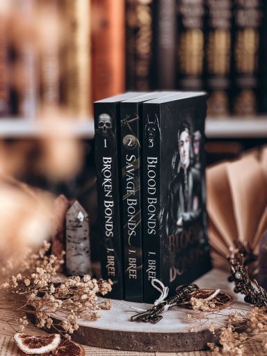 Image provided by Bookstagrammer Steph of a book series, "Broken Bonds" by J Bree, lined up on a table, the shelf blurred in the background.