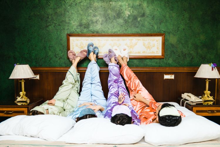 Four girls during a sleepover with their legs up against the wall.