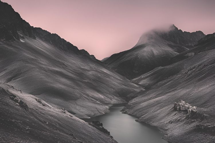 A black-and-white landscape depicting a valley with high mountains against a reddish background.