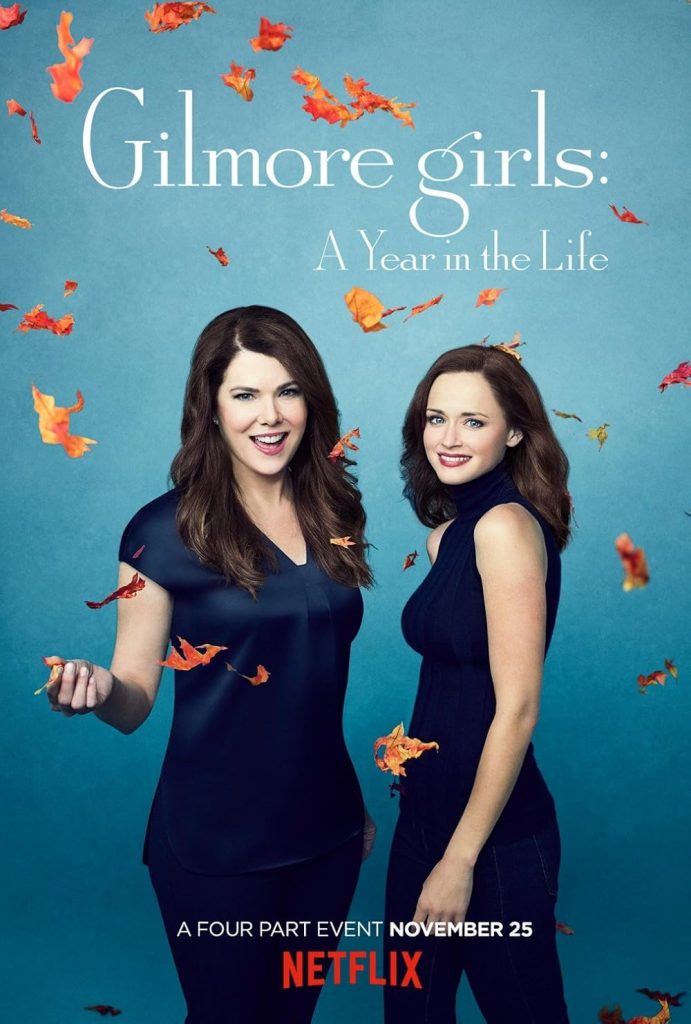Rory and Lorelai Gilmore stand against a blue background with autumn leaves gently falling around them, capturing a cozy fall atmosphere.