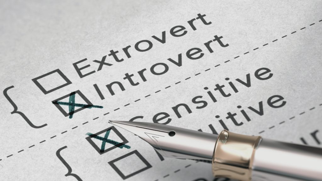 Fountain pen sitting on a piece of paper with personality options. Introvert and sensitive are marked with an x.