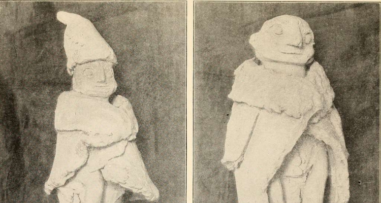 A photo in greyscale depicting two clay statues of little human-esque figures in thick coats.