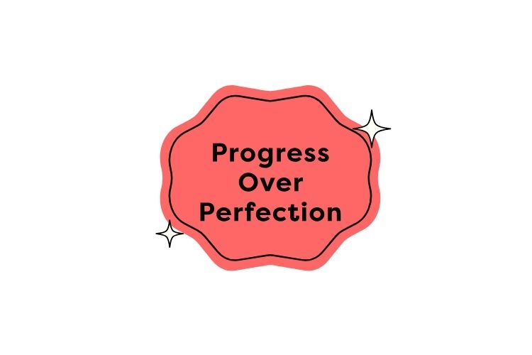 A badge on which the words “Progress Over Perfection” are displayed.