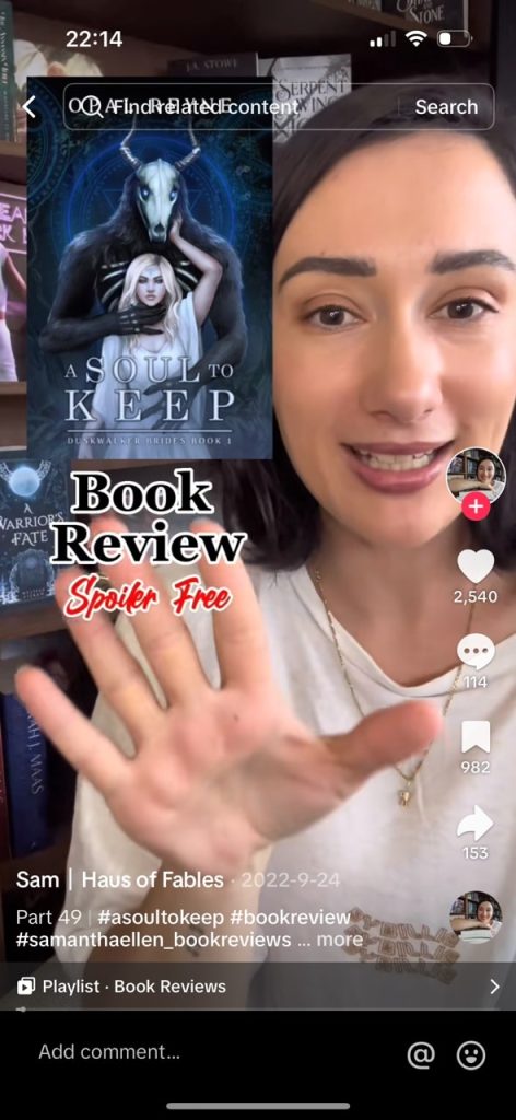 Tiktok video of @haus.of.fables doing a book review of A Soul to Keep, the cover of which is a girl in white in front of a horned skulled and furry demon.
