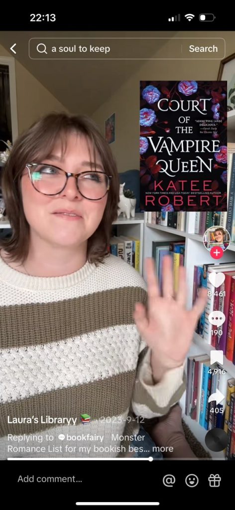 A tiktok video of @lauraslibraryy recommending Court of the Vampire Queen, the cover of which is a black background with purple and red flowers bordering the white text.