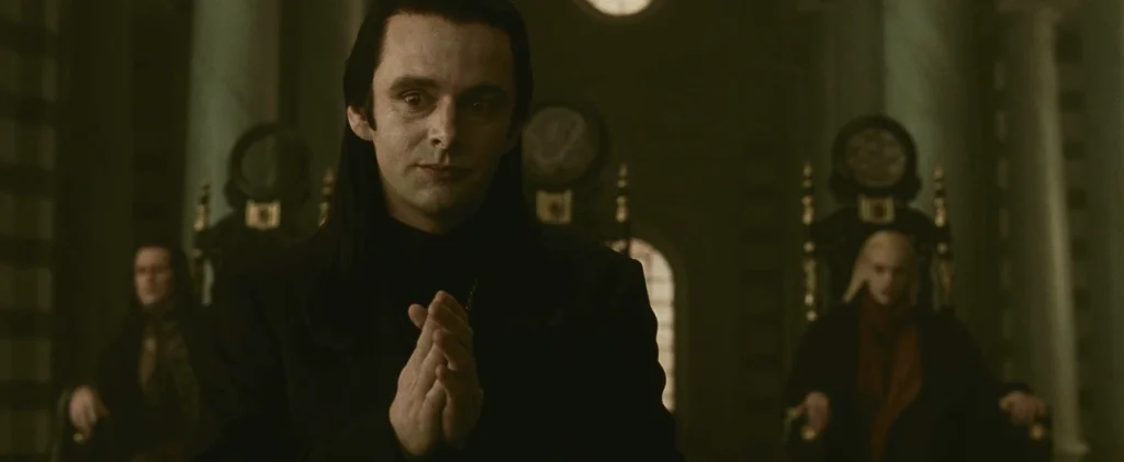 Aro, leader of the Volturi in his council room with two other members as he puts in hands together in thought.
