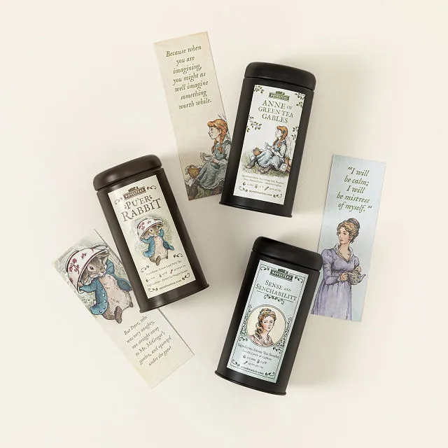 Three long tea canasters with hand drawn women on them.