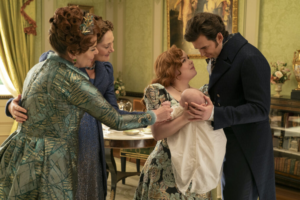 'Bridgerton' season 3 still of Penelope and Colin holding their baby with their mothers by their side.