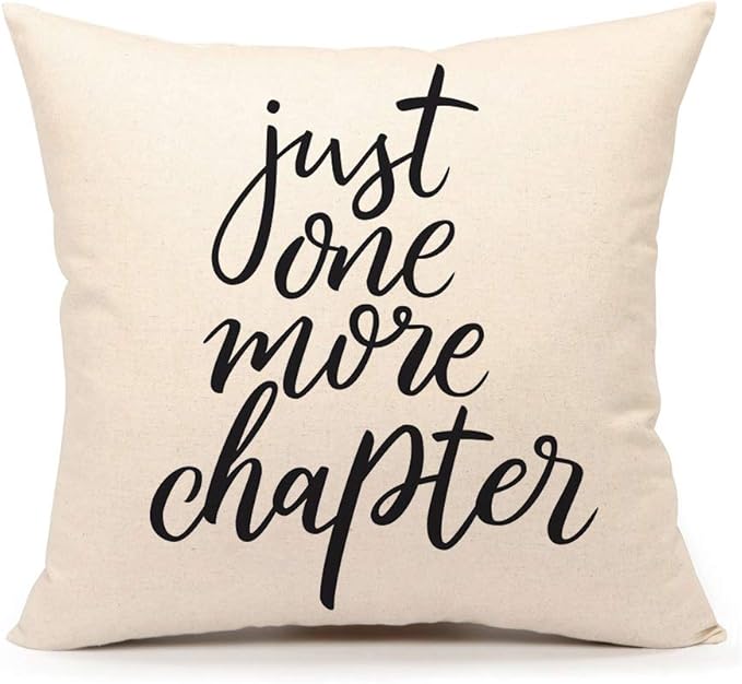 Beige throw pillow with the phrase "just one more chapter" in black cursive.