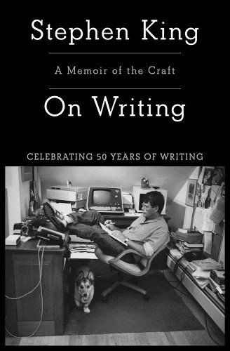 A black book cover with a black-and-white image of Stephen King at his desk, with a dog by his feet.
