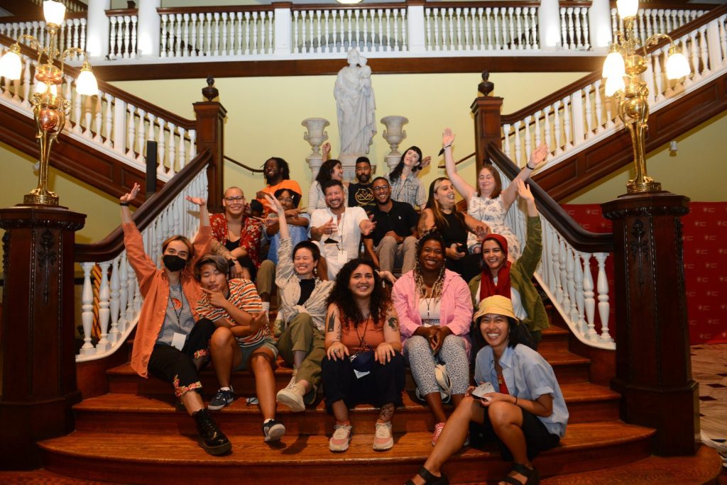A group of laughing and smiling people sitting on a staircase.