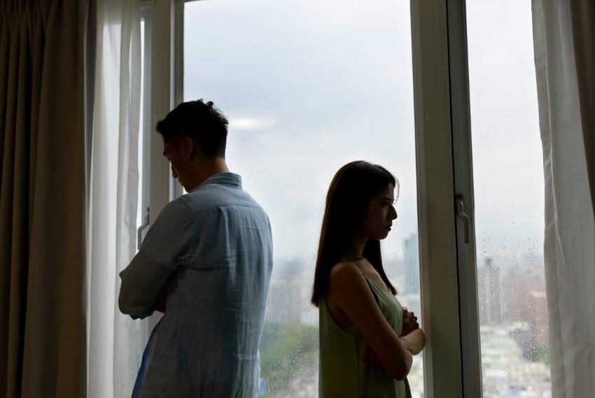 A man and woman with crossed arms facing away from each other