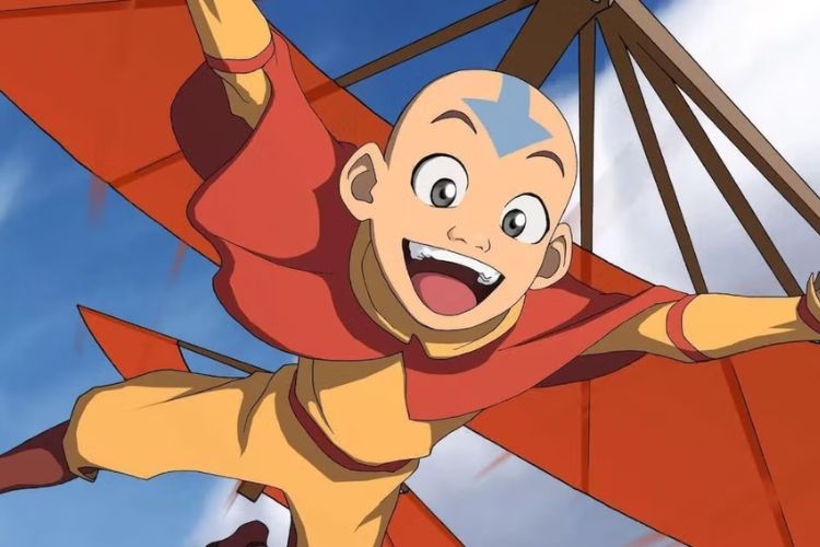 An animation of young boy with a blue arrow tattoo across a shaved head. He wears loose orange and yellow clothes, is excited, and appears to be flying.
