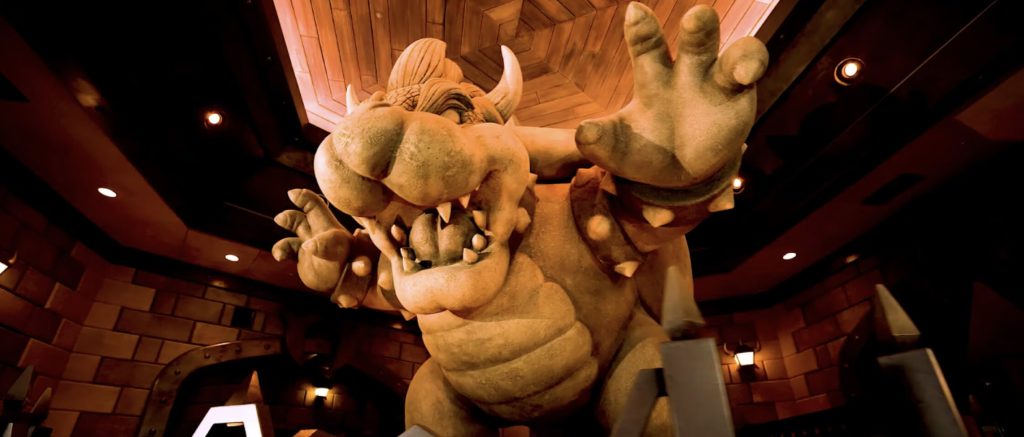 A stone Bowser growls menacingly in a dark room.