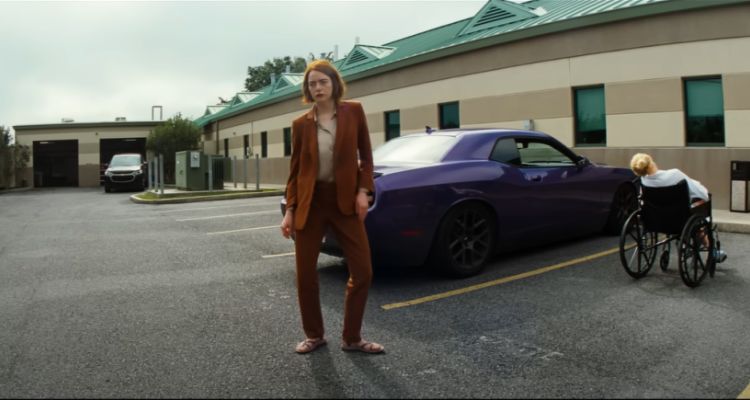 Movie still taken from Kinds of Kindness trailer, framing Emma Stone and Jesse Plemons in the background.