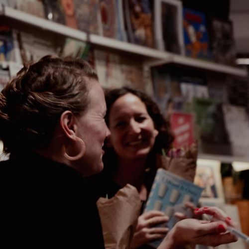 Kate laughing while signing a book