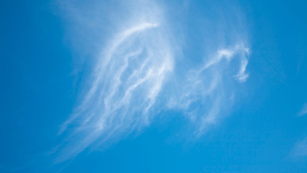 Clouds in the shape of angel wings on a clear blue sky.