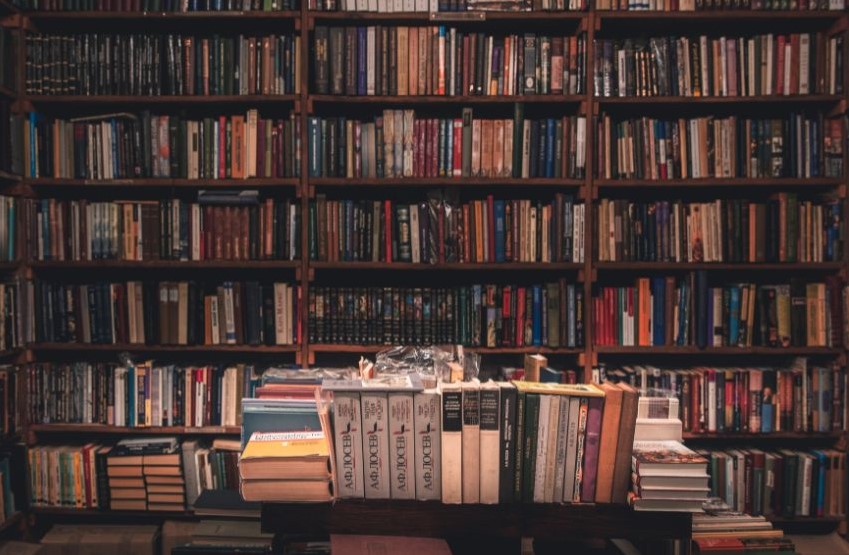 Full bookshelves with books stacked on a table in front of them