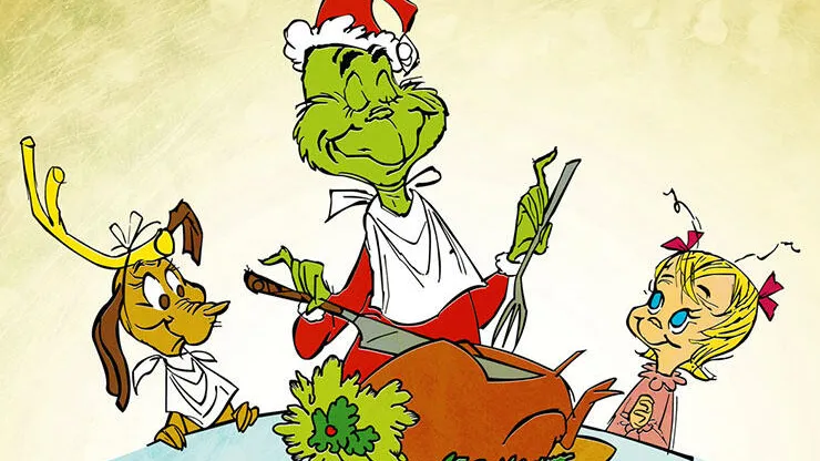 The Grinch cutting up a turkey with Cindy Lou Who and Max smiling at him