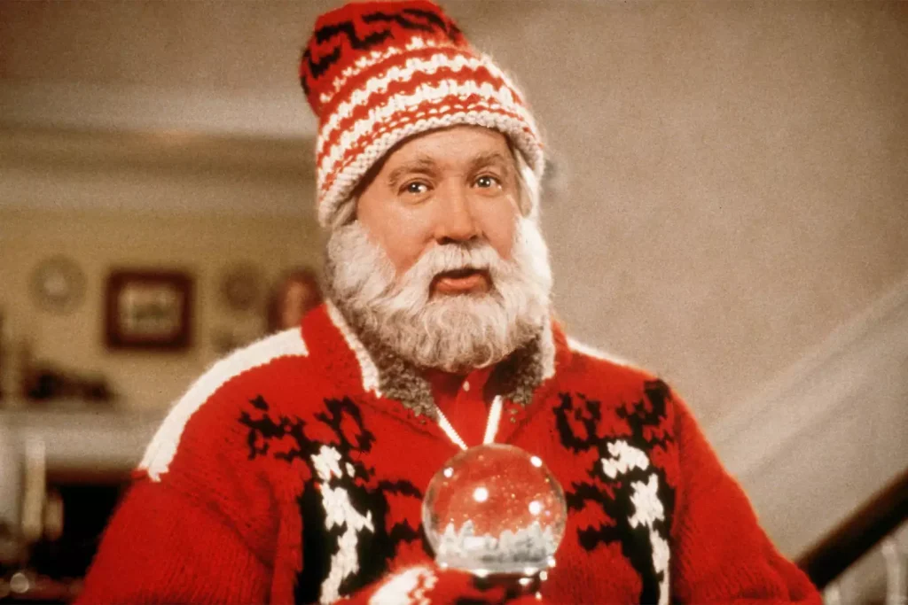 Scott Calvin as Santa holding a snow globe and staring at the camera