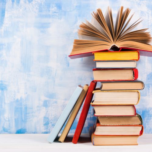 A tall stack of books against a blue and white background.