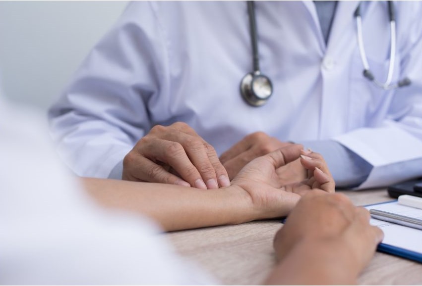 A doctor pressing fingers against a patient's wrist