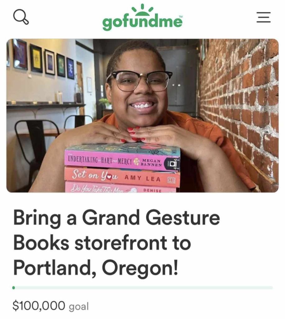 Woman sitting next to a brick wall resting her hands on a stack of books