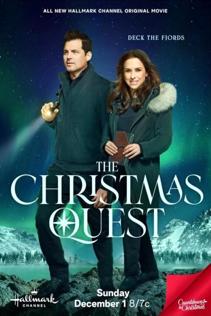 "The Christmas Quest" of the main leads on top of rocks with the northern lights behind them with snow-covered mountains.