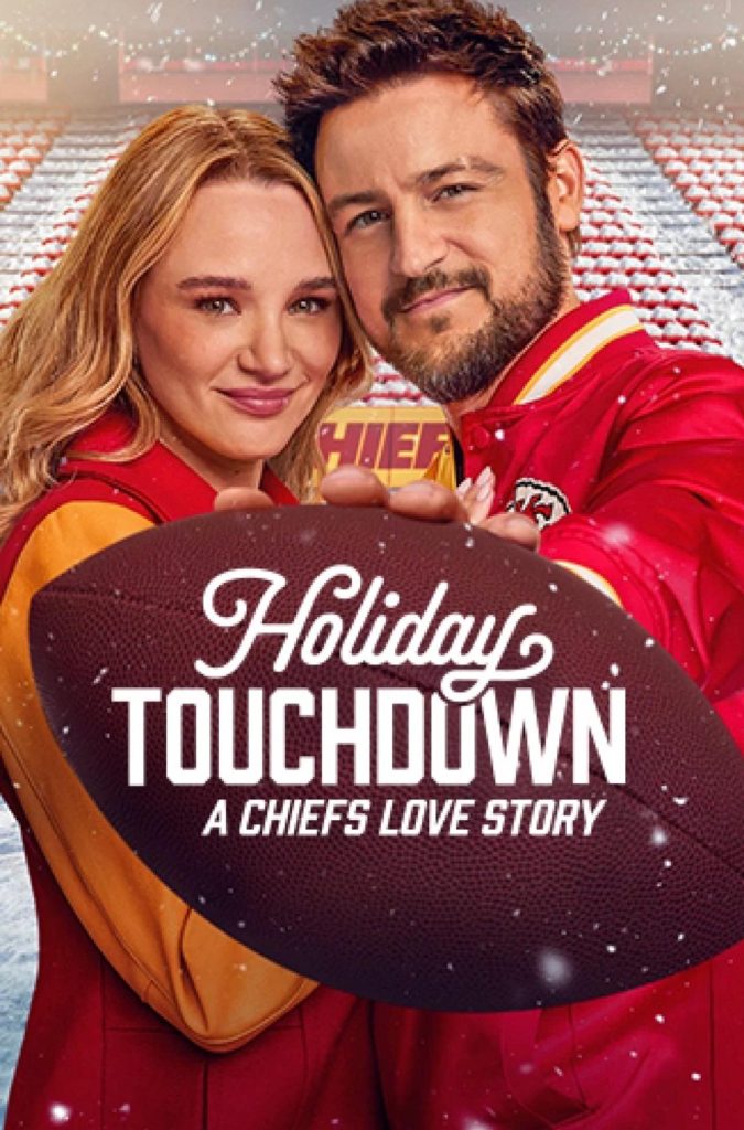 "Holiday Touchdown: A Chief’s Love Story" movie poster of the main leads dressed in football merch with a football stands behind them. One of the characters is holding a football.