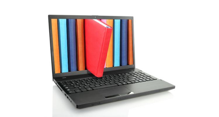 An open black laptop against a white background displays the spines of colorful books, with one book breaking the fourth wall and tipping out of the image on laptop's screen.