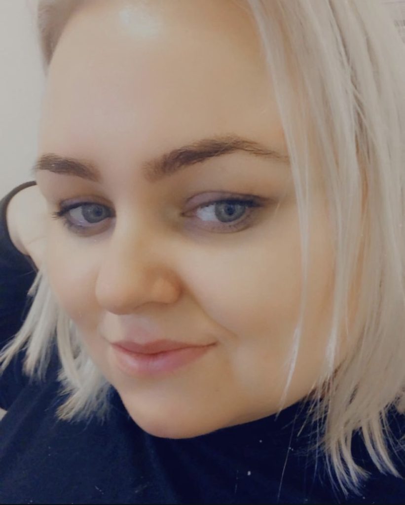 A close-up portrait of Ker Dukey. Her hair is platinum blonde and she is wearing a dark sweater.