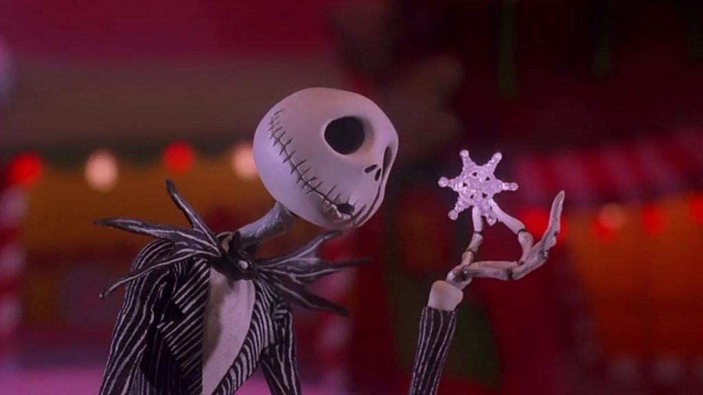 Jack Skellington holiding a snowflake and looking at it while singing.