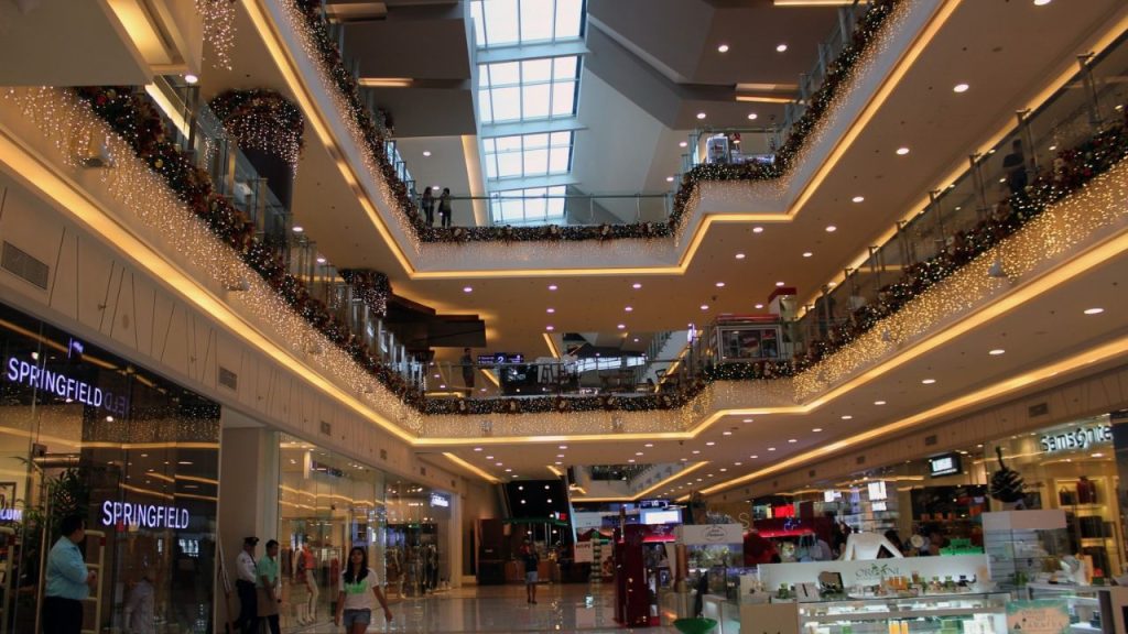 The center of the mall has three floors, the upper two decorated with lights as it hangs.