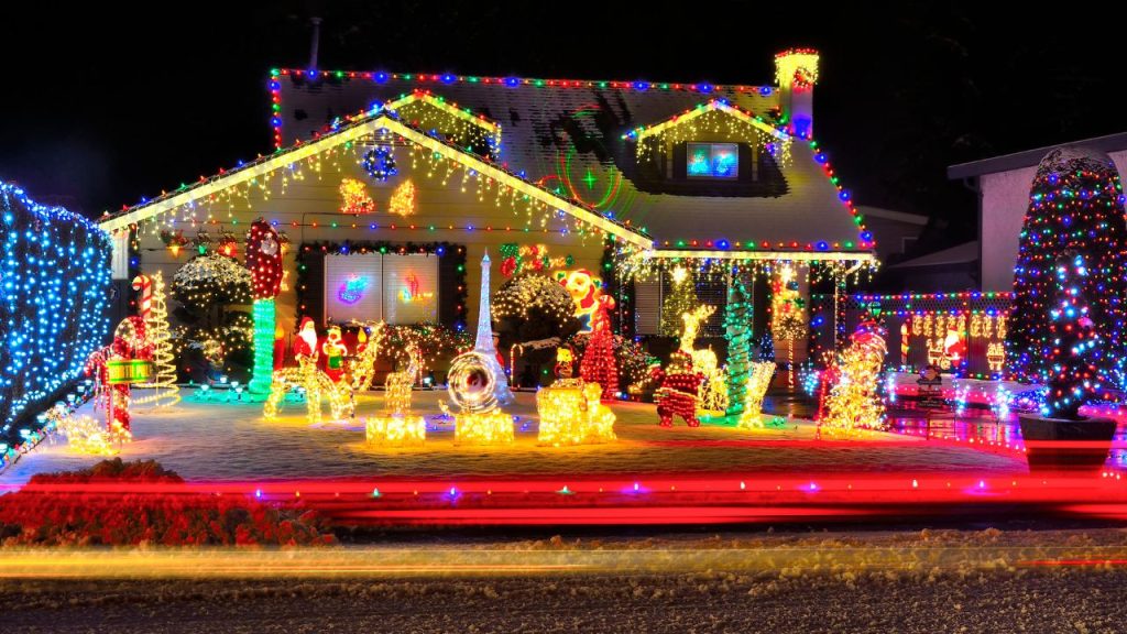A house fully decorated with Christmas lights on the house and light figures on the yard.