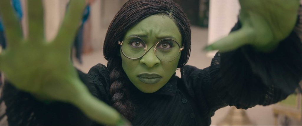 Cynthia Erivo as Elphaba in Wicked (2024) holding her hands in front of her as if casting a spell.