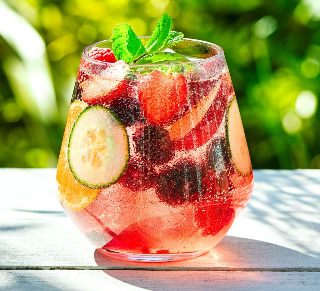 A picture of a bright beautiful mocktail with mixed fruit.