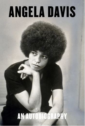 A woman in a black shirt, sits and rests her chin on her wrist as she gazes off on the cover of Angela Davis Autobiography.