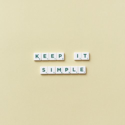 yellow background with white tile words that say keep it simple in green letters.