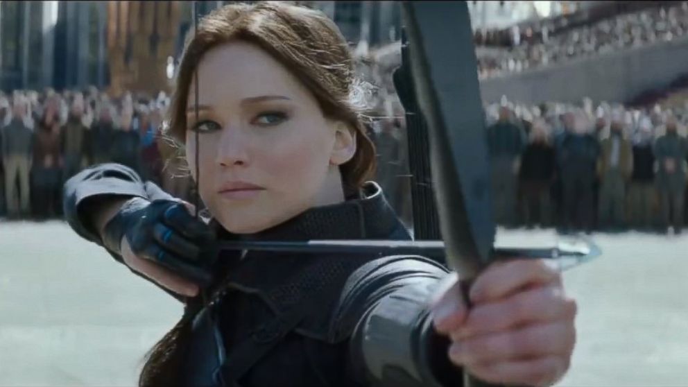 Katniss Everdeen is surrounded by a crowd poised to shoot Coin.