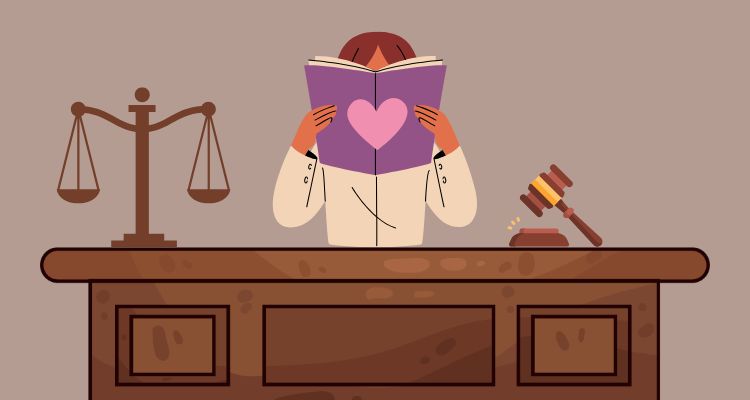 Someone reading a book with a heart on the cover while sitting at a court desk.
