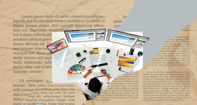 A graphic designer, working at a desk, is buried among torn book pages.