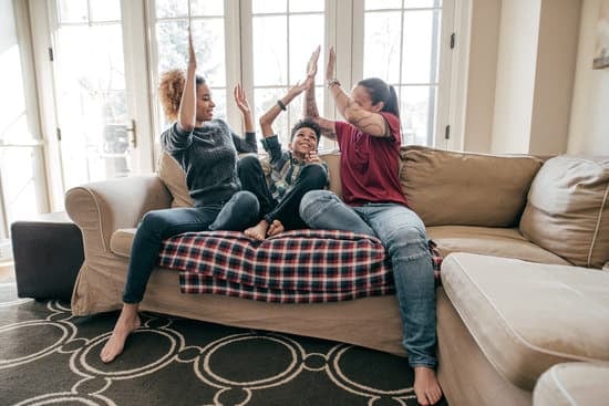 Family of three sits on coach and high-fives.
