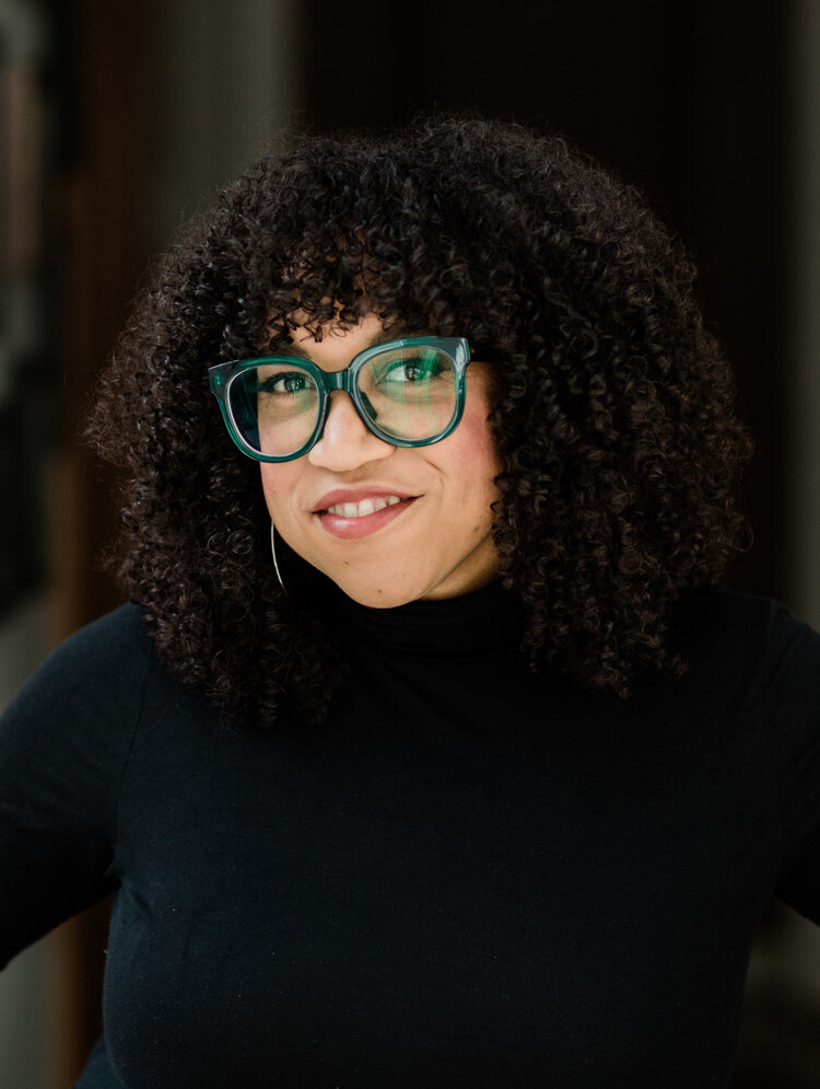 A woman with green glasses smiling.