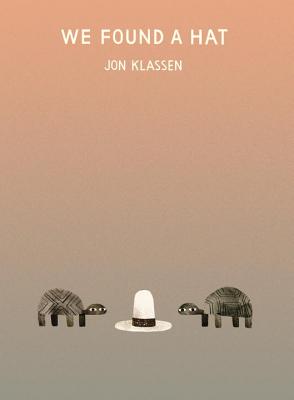 Two turtles face toward a hat on an ombre background with the title: We Found A Hat.