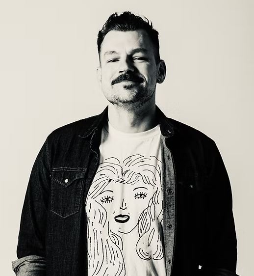 Author in denim jacket and graphic tee.