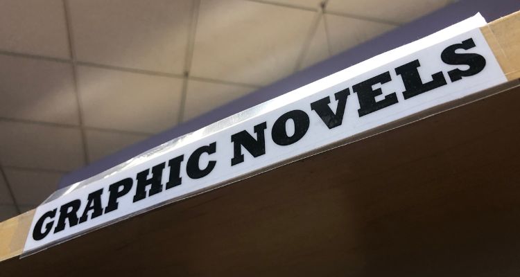 Bold text on a label attached to a shelf reads "Graphic Novels."