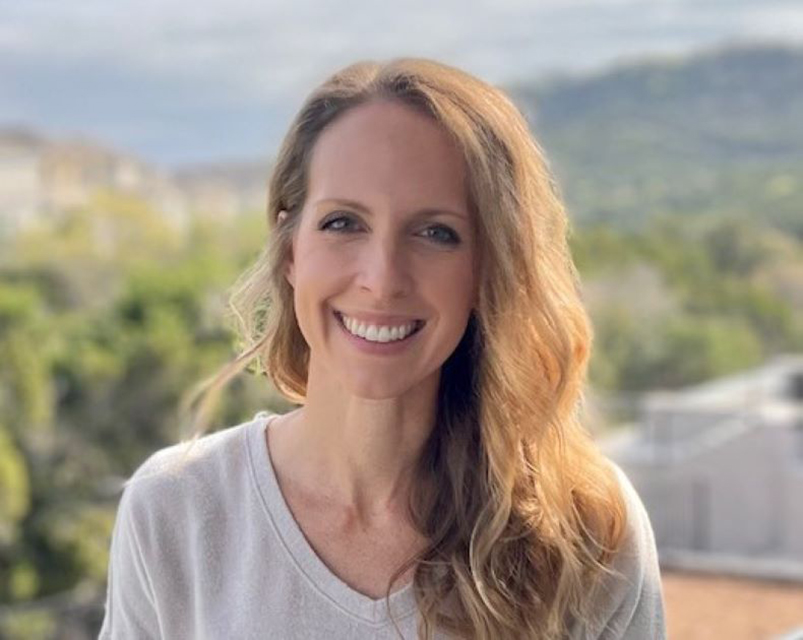 Photo of Ashley Wall, a light-skinned woman with blonde hair and a grey sweater.